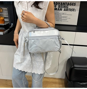 Silver metallic Boston bag with dual zippers and adjustable shoulder strap worn cross-body