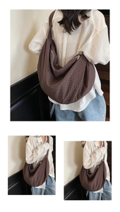 Detail of coffee plaid woven tote bag with crescent shape and large capacity on model