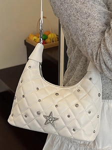 White quilted crescent shoulder bag with silver studs and a rhinestone star emblem