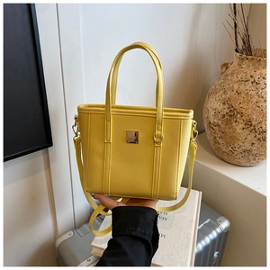 Detail of yellow lychee pattern tote bag with metal square buckle and leather texture