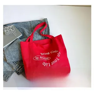 Detail view of red canvas tote bag featuring white Bring Color To Your Life printed text