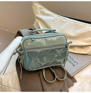 Detail of mint green PVC jelly bag with shiny patent leather finish and dual zippers