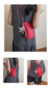 Detail of red bucket bag with litchi texture, silver starfish charm and brand embossing