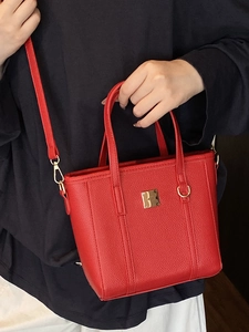 Red lychee grain leather bucket bag with gold hardware and a detachable shoulder strap