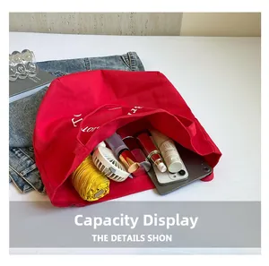 Spacious red canvas tote bag showing interior storage for a tablet, umbrella, and cosmetics