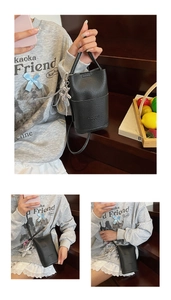 Detail of black litchi grain leather bucket bag with silver floral and star charms