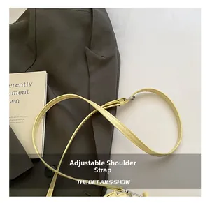Détail de la bandoulière réglable en simili cuir jaune vif avec une boucle argentée