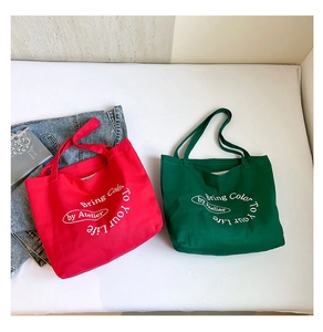Red and forest green canvas tote bags with 'Bring Color To Your Life' print and denim jacket