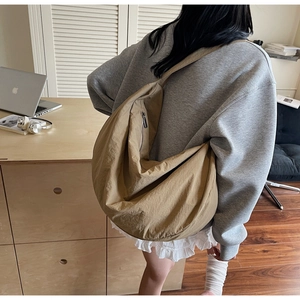 Rear view of a large khaki crescent tote bag with soft pleated fabric and wide strap