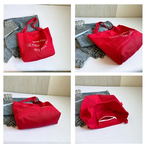 Detail view of red canvas tote bag with inner zipper pocket and artistic text print