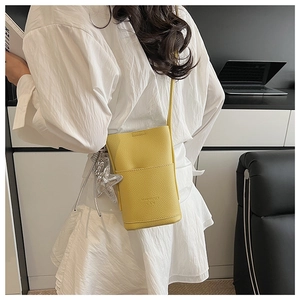 Detail of yellow lychee grain PU phone bag with a silver star charm and exterior pocket