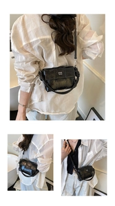 Détail de la texture tissée brillante noire et du nœud latéral de ce sac à bandoulière chic