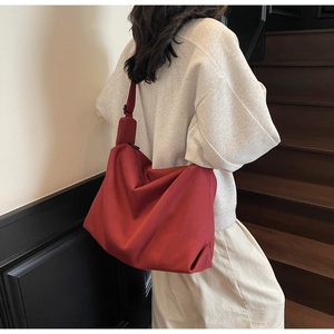 Chic red canvas crossbody bag styled with casual outfit for a minimalist summer look