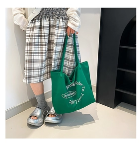 Detail of green canvas tote bag featuring white Bring Color To Your Life printed text