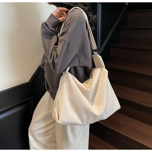 Chic beige oversized hobo bag with wide strap for trendy urban daily commuting style