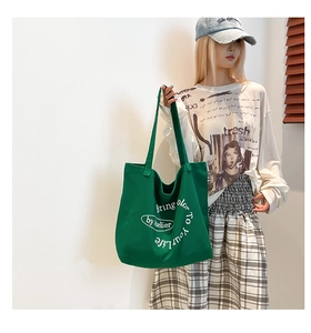 Detail of green canvas tote bag with white Bring color to your life text print