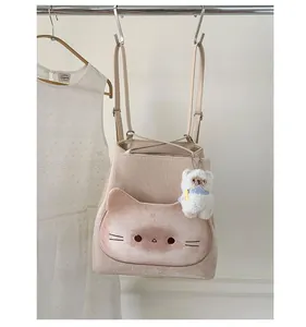 Detail der süßen Tasche in Katzenform am beigen Rucksack mit flauschigem Bären-Anhänger