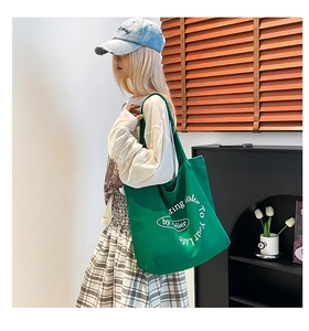 Detail of vibrant green canvas tote bag with white spring color typography