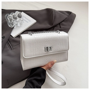 Detail of white crocodile pattern PU leather crossbody bag with silver buckle and chain