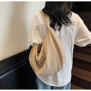 Detail showing high-capacity khaki gingham hobo bag made of textured woven canvas fabric