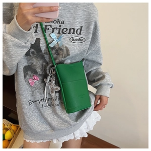 Detail of green litchi grain leather phone bag with silver starfish metal charm