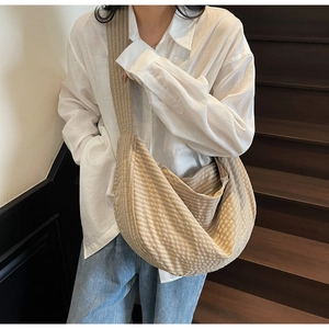 Detail of checkered hobo bag showing large capacity and soft woven fabric on model