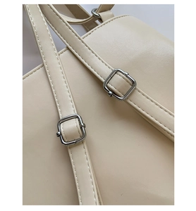 Detail der beigen Ledertasche mit verstellbarer Silberschnalle und präziser Nahtführung