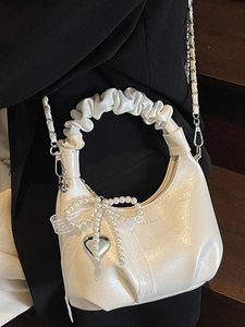 White pearlescent pleated handbag with pearl bow and silver heart chain detail