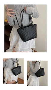 Detail view of black woven texture tote bag showing herringbone embossed faux leather pattern