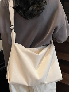 Minimalist off-white canvas crossbody bag with adjustable wide strap for daily commute