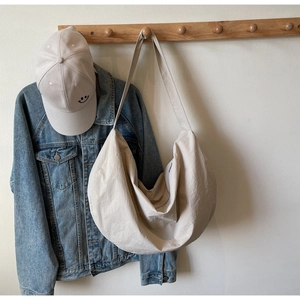 Hanging beige crescent shoulder bag made of textured nylon with minimalist design