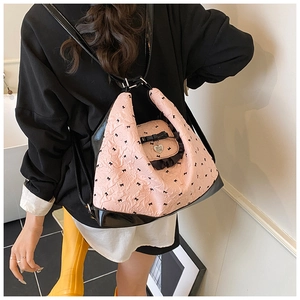 Detail of pink crinkled fabric tote with black bow prints and a heart metal pendant