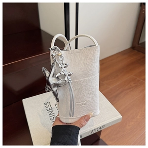 Close-up of white lychee pattern mini phone bag with silver star and dog charms