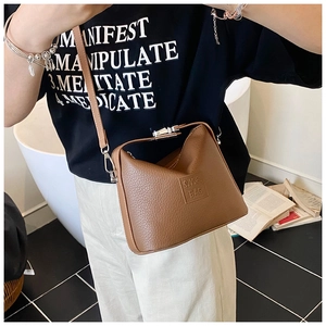 Detail of caramel lychee grain leather handbag featuring silver lock and S.Y.& BAG logo