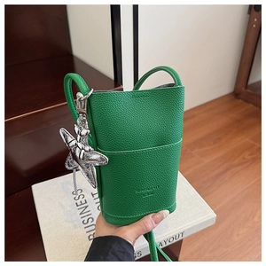 Detail of green litchi grain leather phone bag with silver star charm and embossed logo