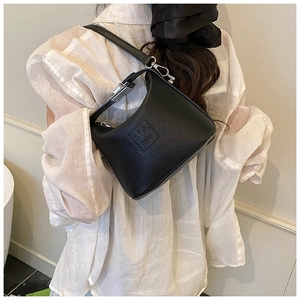 Detail of black lychee grain leather hobo bag featuring embossed logo and silver hardware