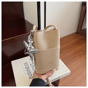 Detail of light khaki lychee pattern leather mobile phone bag with silver star charm