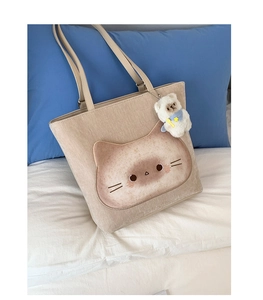 Detailansicht der beigen Segeltuchtasche mit Katzenmotiv und Plüschbär-Anhänger