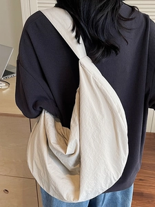 Large beige woven shoulder tote bag with pleated texture shown in a casual office setting