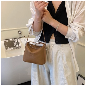 Detail of a brown lychee pattern leather shoulder bag with silver metal zipper and D-ring