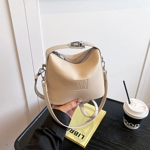 Detail view of cream lychee texture handbag with SV&BAG embossed logo and metal clasp