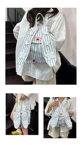 Detail of blue striped bunny ear backpack with plush star and cherry embroidery detail