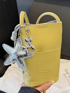 Bright yellow lychee grain leather phone bag with silver starfish and balloon dog charms