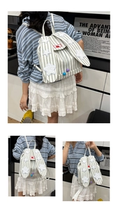 Detail of pink striped canvas backpack featuring rabbit ears and white star embroidery