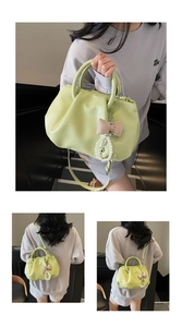 Detail of light green pleated handbag with decorative pearl and bow charms on soft leather