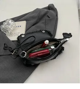 Intérieur spacieux du sac plissé noir avec un portefeuille rouge et un smartphone