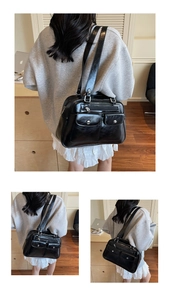 Detail view of black patent leather bowling bag with multi-pocket design and silver hardware