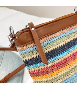Detail der bunten Regenbogen-Stroh-Minitasche mit Reißverschluss und braunem Lederbesatz