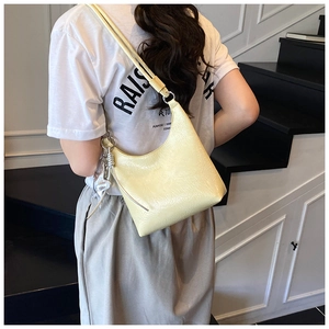 Détail du sac hobo crème avec anneau métallique argenté et foulard en soie décoratif