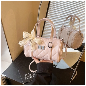 Detailed view of pink quilted boston bag with lace bow and elegant metal twist lock